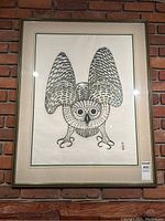 Full view of framed print hanging on brick wall
