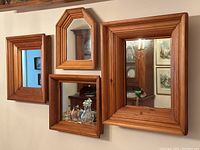 Group of four pine framed mirrors hung on wall