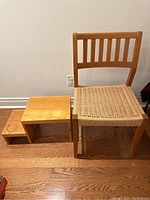 View of the Danish modern chair next to a solid wood step stool with three sized steps.
