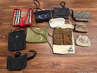 Full view of 10 purses and handbags with various sizes, colors and materials, arranged on wood floor.