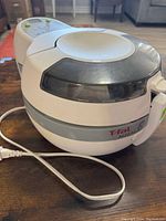 Photo of the closed T-fal ActiFry air fryer showing outer body with brand logo and power cord.