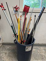 Bucket filled with assorted clamps, rods, poles and shovel head