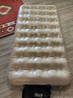 Top view of single inflatable air mattress, tufted and light beige/taupe.