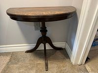 Front and side view of the half moon table showing the pedestal base and claw feet.
