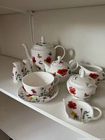 MacIntosh floral tea set pieces including teapot, sugar bowl, creamer, cup and saucer, small creamers.