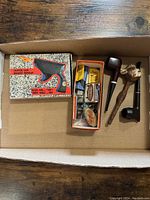 Box containing three vintage pipes, cigarette lighter gun in original box, and a small box with lighter parts