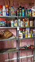 Photo of many assorted household products on metal shelf. Includes aerosol cans, spray bottles, and liquid bottles of various household cleaners and maintenance products.