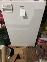 Front view of a small white Absocold refrigerator, showing the brand label on the door and minor surface blemishes.