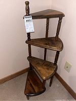Full view of wooden spiral stair-shaped corner stand with four small shelves, showing the stair-step design and triangular shelves.