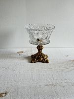 Front view of the small candy dish showing the decorative cut glass bowl and brass pedestal base.