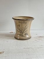 Front view of beige Canfloyd pottery vase featuring faux crazing and botanical illustration with plant and bulb detail