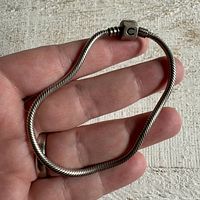 Bracelet being held in hand showing full length and style of silver snake chain.