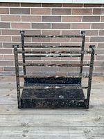 Front view of large metal firewood rack showing twisted bar details and solid base