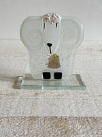 Front view of the clear fused glass lamb figurine with white and black painted details, mounted on a rectangular glass base