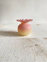 Front view of the vintage Burmese ruffled ball vase showing its pink and yellow gradient color.