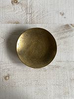 Top view of the small round brass bowl showing the dragon etched design inside