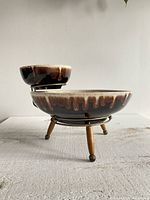Side view of vintage brown drip glaze chip and dip set on wooden-leg metal stand
