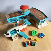 Full view of the airport playset including airplane, airport building with control tower, figures, and accessories on tabletop.