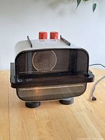 Front view of the Braun convection oven showing the glass door, two orange control knobs, and overall shape.