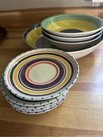 Stacked six small saucers, ceramic with multicolor concentric designs accented with blue on edges