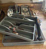 Overview shot showing metal spoon, cutlery trays, meat forks with carved wood handles, and bamboo spoons