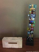 Full view of glass art sculpture and commemorative brick side by side.