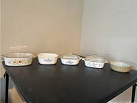 Photo showing five ceramic baking dishes lined up left to right, showcasing varying sizes and floral patterns.