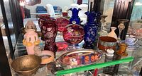Hand painted cobalt blue vases, cranberry candy dish, pottery, candle holders and silver plated tray on glass shelf