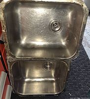 Top view of double stainless steel kitchen sink showing both basins and drains.