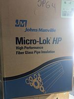 Cardboard box label showing Johns Manville Micro-Lok HP branding and indication of high performance fiber glass pipe insulation.