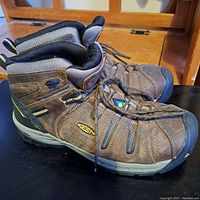 Side view of brown Keen Utility work boots showing leather and fabric construction, lace-up design, and Keen logo on side.