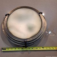 Top view of the round frosted glass diffuser with metal frame, showing approx 12.5 inch diameter with measuring tape.