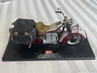 Overall photo of the 1942 Indian motorcycle scale model on black base, showing side profile with saddlebags and seat