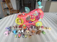 Front view of the pink and yellow Littlest Pet Shop vehicle with multiple small animal figures arranged in front.