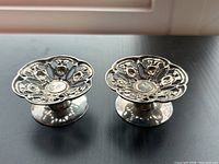 Pair of sterling silver Birks candleholders placed side by side showing the top view and design details