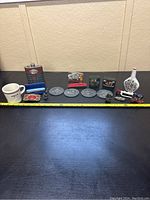 Full lot showing mug, flask, harmonicas, Disney medals, small figurines, plates arranged with measuring tape in background.