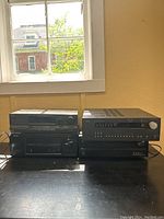 Four receivers stacked on table under window
