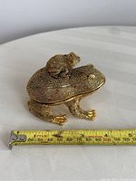 Large frog trinket box with a measuring tape for size reference approximately 4 inches long