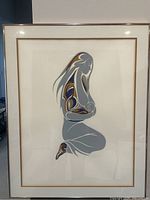 Full view of the framed artwork showing the stylized kneeling woman holding child in indigenous art style.