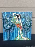 Front view of the ceramic art tile with detailed artwork showing an Asian woman and crane motifs on a blue background.