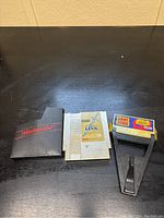 Full kit including black Nintendo branded sleeve, gold Zelda II game cartridge, and Game Genie enhancer