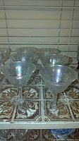 Set of six crystal stemmed drinking glasses placed on a tiled surface showing general shape and quantity.