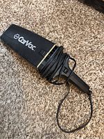 Front view of the CarVac handheld vacuum cleaner showing the brand name and nozzle shape with cord wrapped around the body.