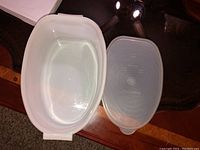 Top view of white ceramic dish and translucent plastic lid, showing interior and lid detail.