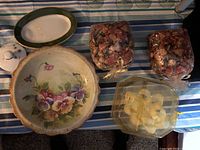 Top-down view of two ceramic plates, oval dish, two potpourri bags, and plastic candle holder with candles