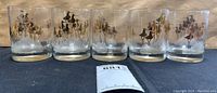 Set of 5 clear glasses with gold and black bird motifs, showing the full group in one line.