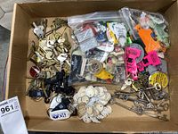 Box lid filled with assorted keys, skeleton keys, and numerous keychains in plastic bags and loose.
