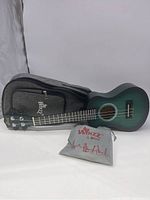 Full view of green Winz ukulele with gray Winz carrying case and accessories pouch in front