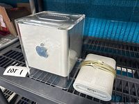 Front and side view of Power Mac G4 Cube with power adapter