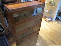 Front view of entire 3-tier barrister bookcase showing three glass-front sections and oak frame.